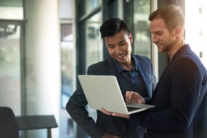 Shot of two businessmen discussing something on a laptop in an office