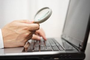 businessman is using magnifying glass on computer laptop. Internet search and protection concept